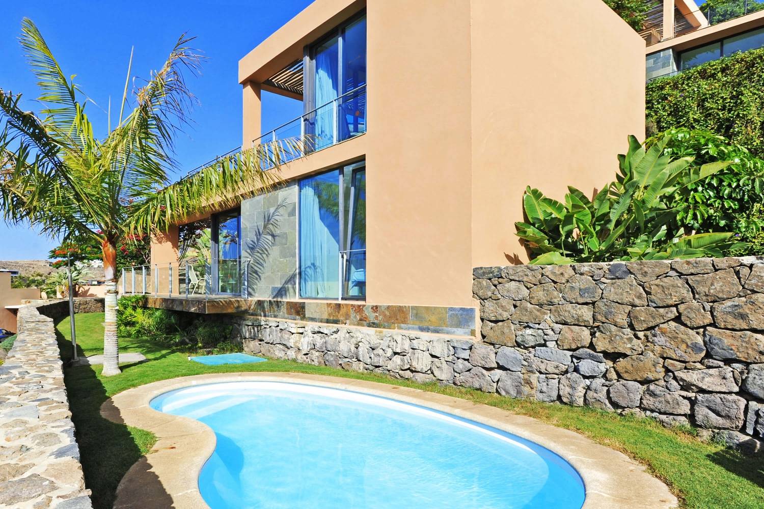Bright villa med store glasvinduer, afslapning områder udendørs, opvarmet privat pool og udsigt over golfbanen