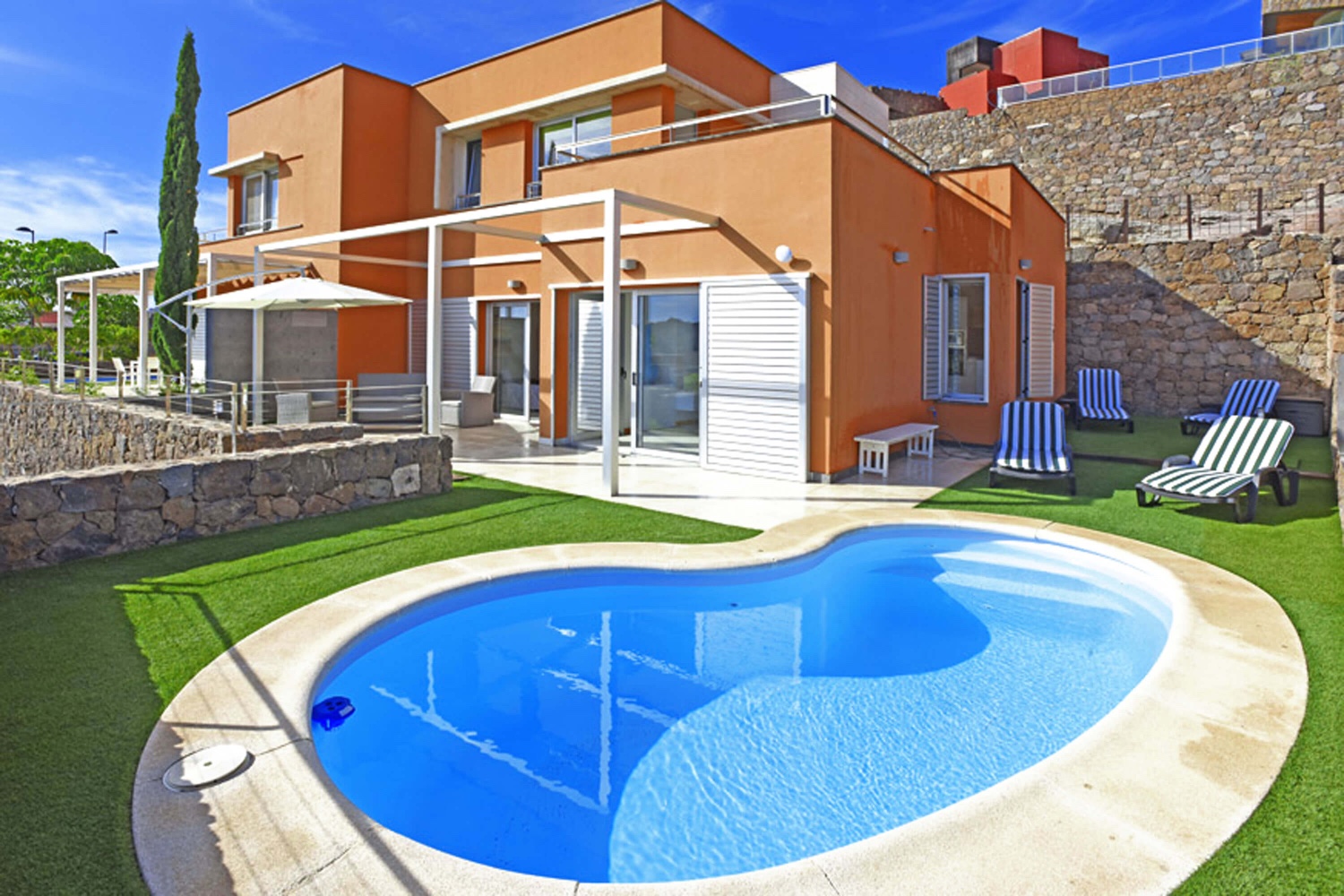 Lyst to-roms hus med hyggelig utendørs avslapningsområde og privat oppvarmet basseng